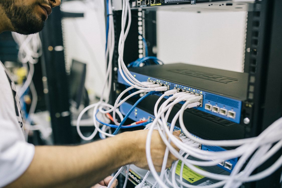 System Integrators & OEM 1 Technician connecting network cables in an equipment rack